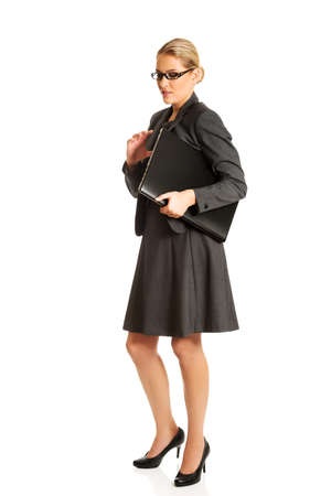 Businesswoman standing and holding a laptopの写真素材