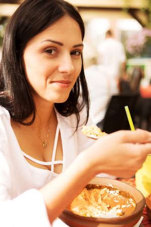 Young woman is eating in restaurant.の写真素材