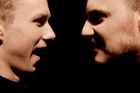 Side view on two screaming menの写真素材