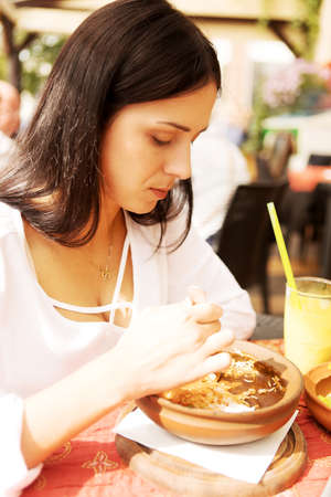 Young woman is eating in restaurant.の写真素材
