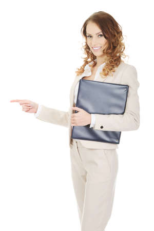 Happy businesswoman pointing with clipboard.の写真素材