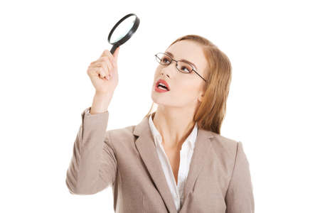 Beautiful business woman looking through magnifying glass.の写真素材