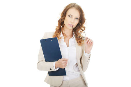 Thoughtful businesswoman with clipboard.の写真素材