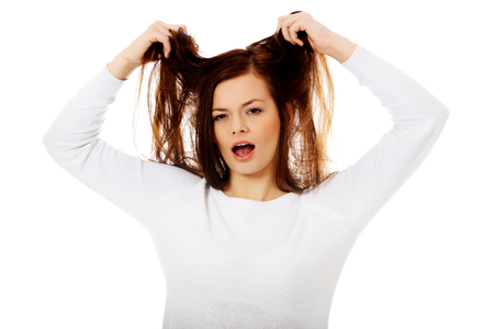 Young angry woman pulling her hairの写真素材