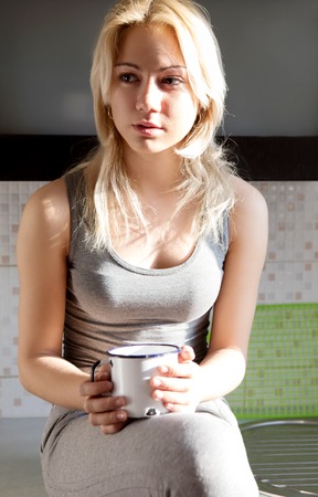 Woman drink coffee or tea in old mugの写真素材