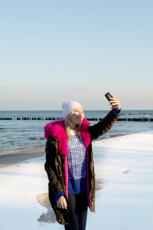 Beautiful young teen girl having fun and making selfie.の写真素材