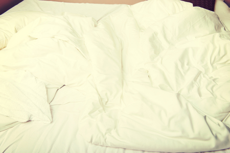 White bedcloth lying on bedの写真素材