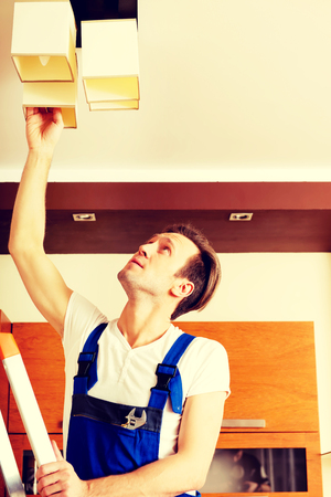 Young electrician working change a bulb at homeの写真素材
