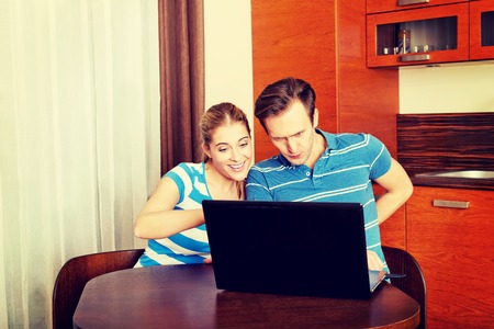 Young couple looking for something on laptopの写真素材