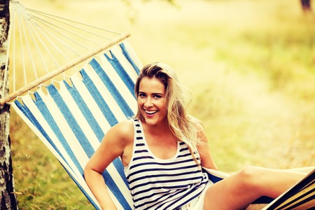 Young blonde woman resting on hammockの写真素材