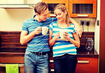 Young couple drinking coffee or tea in kitchenの写真素材
