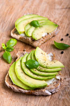 Sandwich with avocado slices and basil.の写真素材