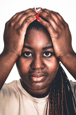 Troubled black woman with hands on headの写真素材