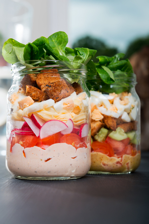 Two glass jars with fresh salad.の写真素材
