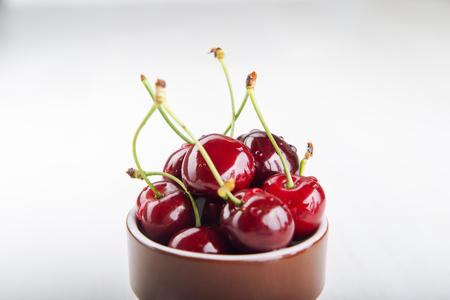 Juicy fresh cherries in brown cup.の写真素材