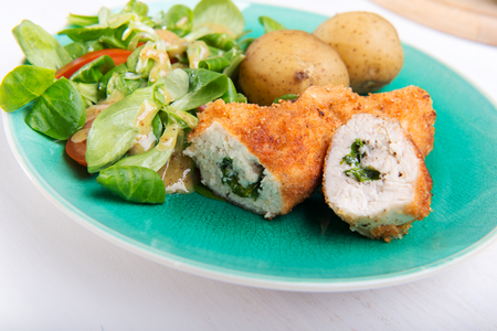 Kiev cutlet with jacket potatoes and salad.の写真素材