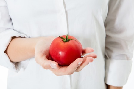 Fresh red tomato on woman open palm.の写真素材