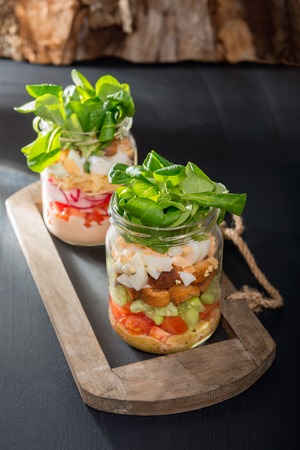 Two glass jars with fresh salad.の写真素材