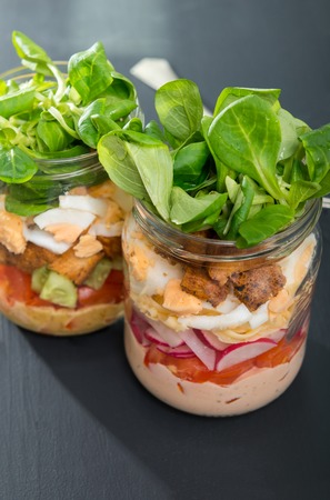 Two glass jars with fresh salad.の写真素材