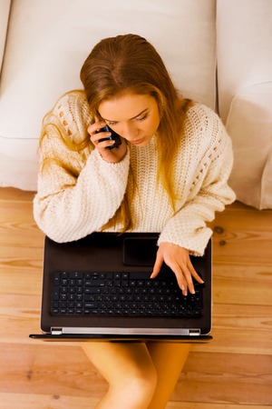 Telesales. Using laptop and phoneの写真素材