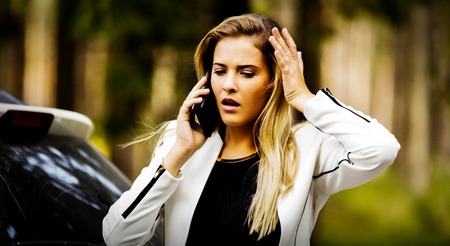 Woman calling to report car accident on the roadの写真素材