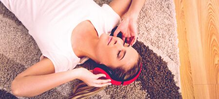 Woman with headphones on floorの写真素材