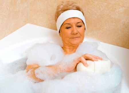 Woman washing in bathtubの写真素材