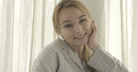 Pretty young smiling woman relaxing at home.