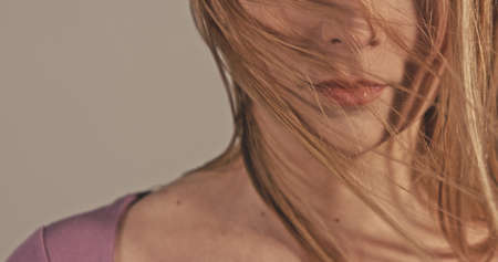 Woman's hair are moving with wind. Camera focus on mouth. Gender concept.の写真素材
