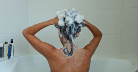 Woman washing hair with dandruff shampoo. Skin hair treatment.の写真素材