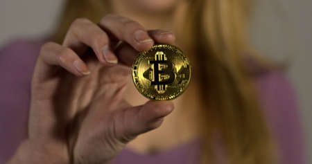 Business woman showing gold bitcoin coin. Cryptocurency market concept.の写真素材