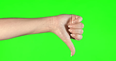 Female hand gestures on green screen: thumbs up.