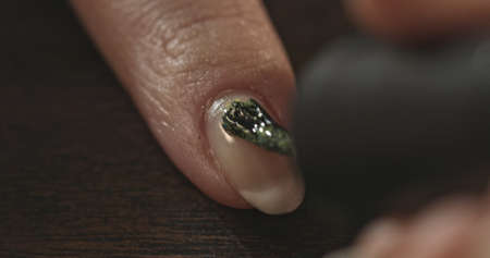Nails saloon. Woman doing new nails and manicure. Macro shoot.の写真素材