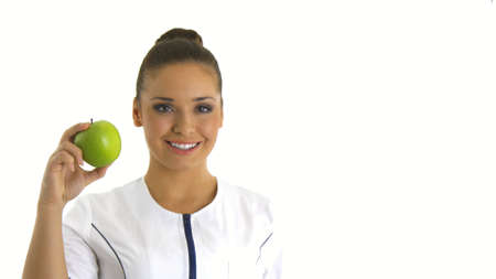 Nurse or young doctor holding an apple smiling.の写真素材