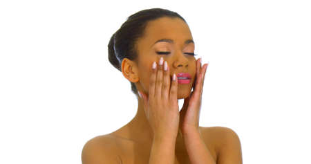 Young beautiful woman massaging or applying cream on her face, isolated on whiteの写真素材