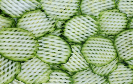 Decorated background of sliced snake gourds