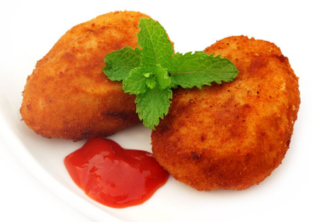 Potato chops with tomato ketchup and fresh mint leaves