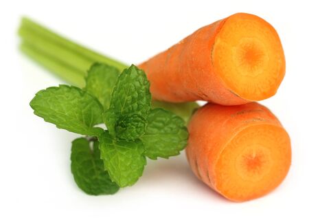 Sliced carrot with mint over white backgroundの写真素材