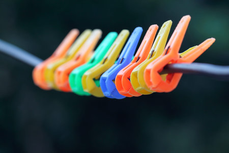 Close up of some multicolor clothespins hanging in rope