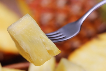 Macro of sliced pineapple with fork の写真素材