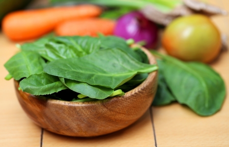 Fresh spinach with some other vegetables on wooden surfaceの写真素材