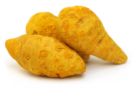 Pile of dried turmeric over white backgroundの写真素材