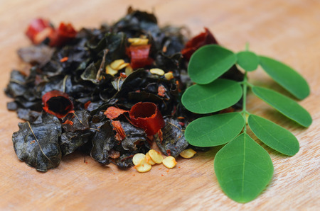 Fried and moringa leaves on wooden surfaceの写真素材