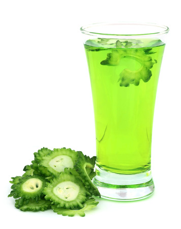 Herbal juice of green momodica in glass over white backgroundの写真素材
