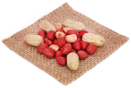 Fresh Peanuts in sack over white background
