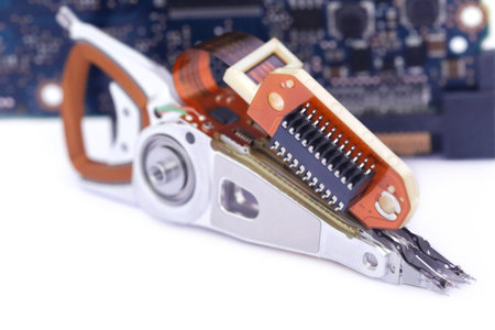 Open hard disk reader head with ciccuits over white background