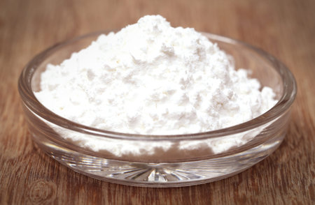 Baking powder in a glass bowl on wooden surface