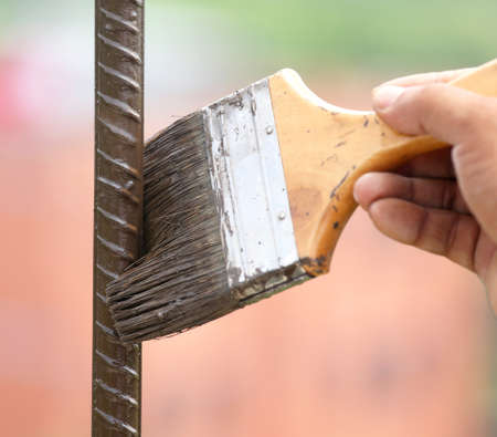 Painting an iron rod outdoor with a brushの写真素材