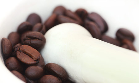 Crushing coffee beans in a mortar with pestleの写真素材