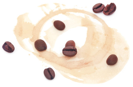 Roasted coffee with cup stain over white backgroundの写真素材